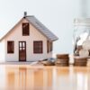 model home and jar of coins sitting on a table